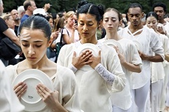 Participants in “The Table of Silence Project” holding plates that symbolize a peace banquet